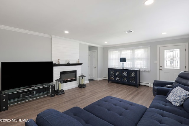 living room with visible vents, ornamental molding, wood finished floors, baseboards, and baseboard heating