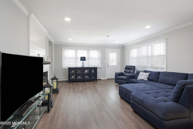 living area with visible vents, a fireplace, wood finished floors, and crown molding