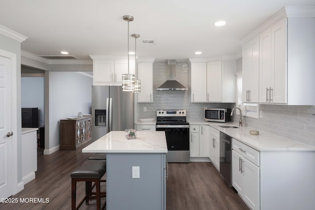 kitchen featuring visible vents, white cabinetry, stainless steel appliances, and wall chimney range hood