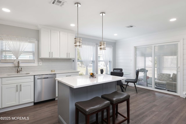 kitchen featuring dishwasher, ornamental molding, visible vents, and a sink