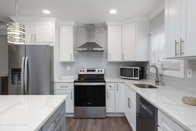 kitchen featuring a sink, appliances with stainless steel finishes, wall chimney exhaust hood, white cabinets, and dark wood-style flooring