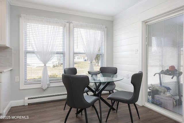 dining room with wood finished floors, a healthy amount of sunlight, and a baseboard radiator