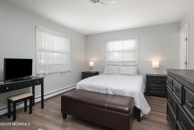 bedroom with dark wood finished floors, visible vents, and a baseboard radiator