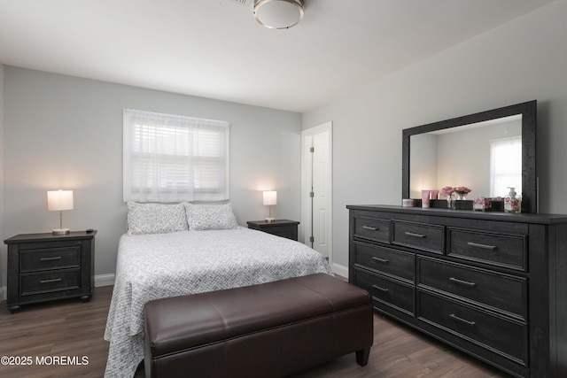 bedroom with dark wood finished floors and baseboards