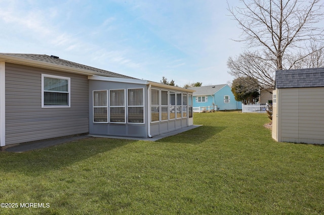 view of yard featuring an outbuilding, a storage shed, and a sunroom