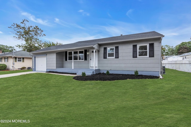 ranch-style home featuring fence, a front yard, roof with shingles, a garage, and driveway