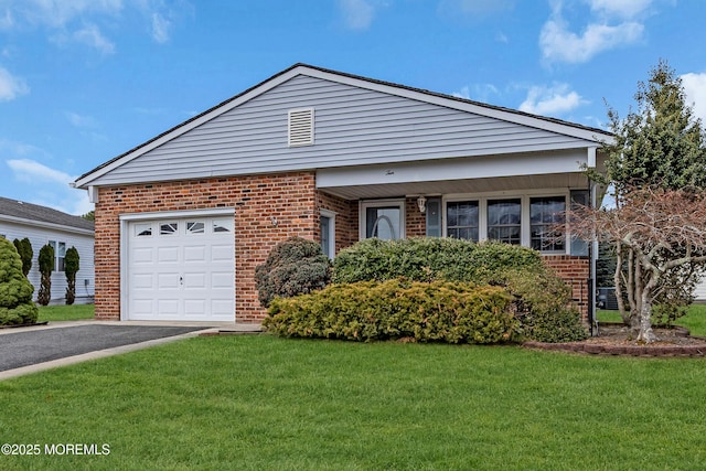 view of front of home with a garage, driveway, brick siding, and a front lawn