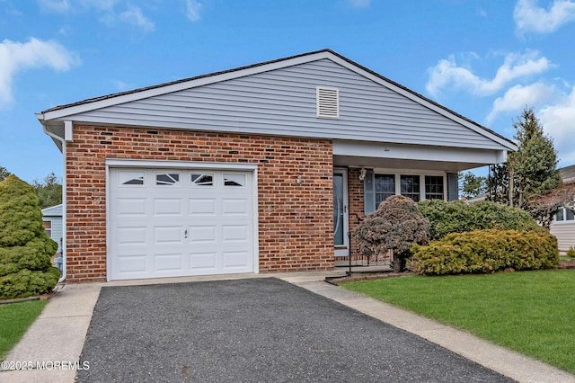 view of front facade with brick siding, driveway, and a front yard