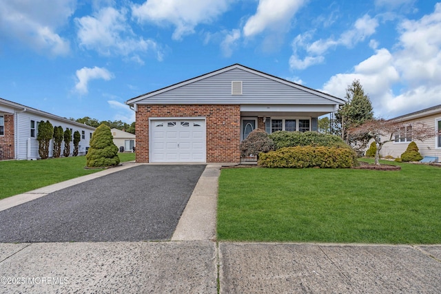 view of front of property with brick siding, aphalt driveway, a garage, and a front lawn