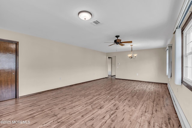 spare room with visible vents, light wood-style flooring, ceiling fan with notable chandelier, a baseboard radiator, and baseboards