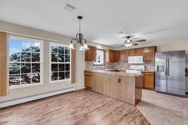 kitchen featuring white appliances, backsplash, visible vents, and baseboard heating