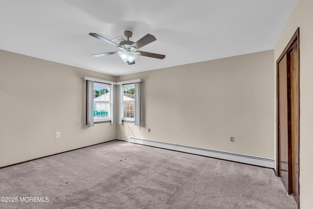 spare room featuring a ceiling fan, a baseboard heating unit, and carpet