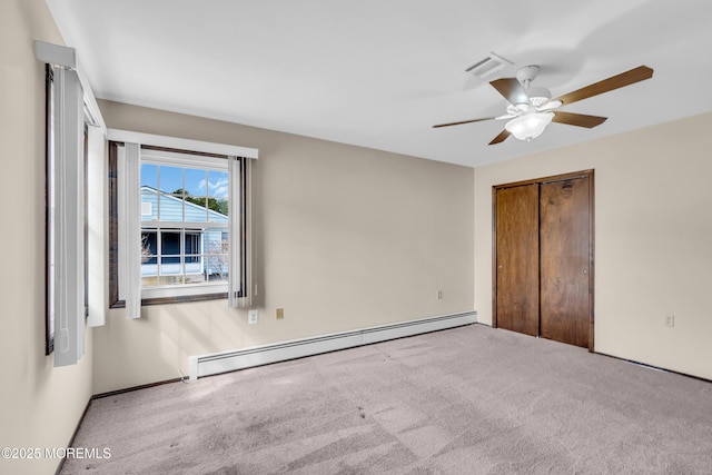 unfurnished bedroom with a closet, carpet floors, baseboard heating, and ceiling fan