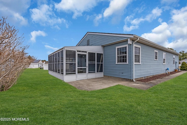 back of house featuring a patio, a lawn, and a sunroom