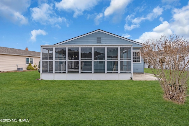 rear view of property with a lawn and a sunroom