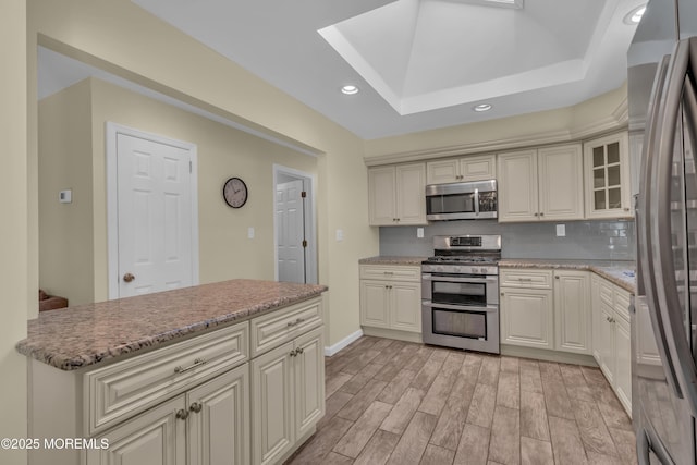 kitchen with light wood-style flooring, recessed lighting, appliances with stainless steel finishes, a skylight, and decorative backsplash