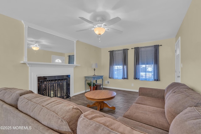 living room featuring wood finished floors, a fireplace, baseboards, and ceiling fan