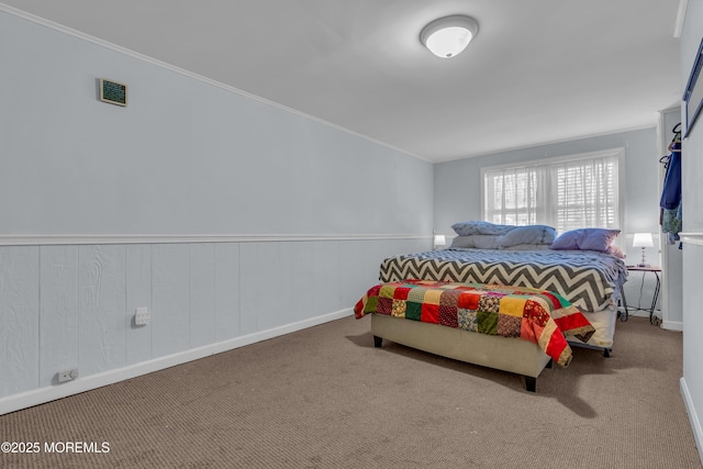 bedroom featuring wainscoting, visible vents, carpet floors, and ornamental molding