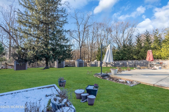 view of yard featuring an outbuilding, a storage shed, and fence