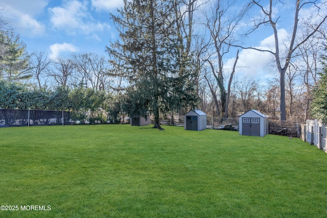 view of yard featuring an outbuilding, a fenced backyard, and a shed