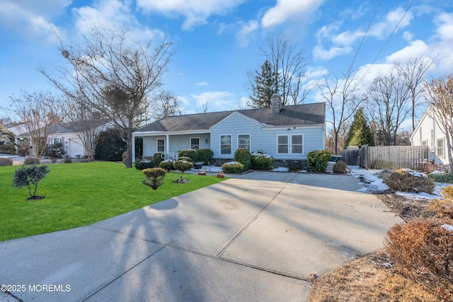 ranch-style house featuring a chimney, a front yard, and fence