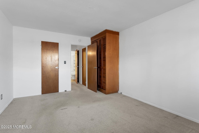 unfurnished room featuring baseboards and light carpet