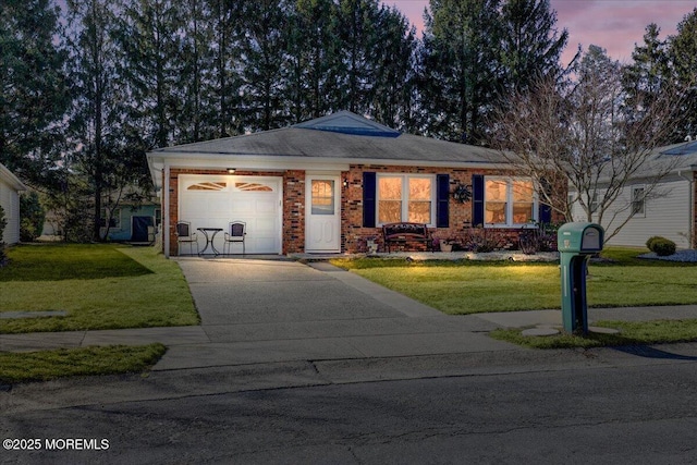 ranch-style house with concrete driveway, a yard, brick siding, and an attached garage