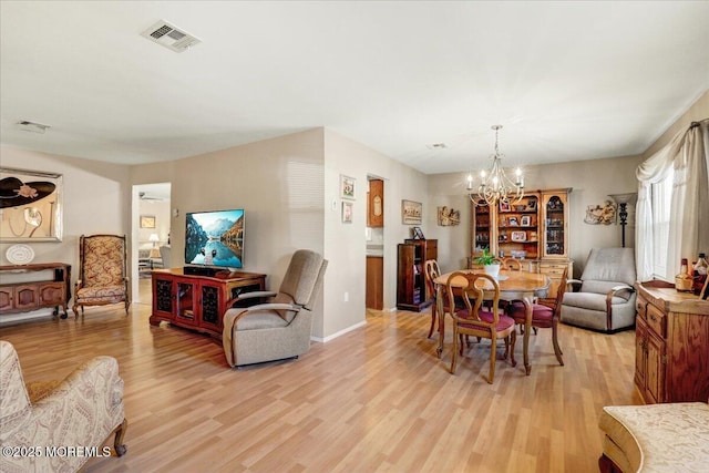 dining room with light wood-type flooring, visible vents, baseboards, and a chandelier