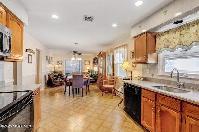 kitchen featuring visible vents, black appliances, a ceiling fan, a sink, and light floors