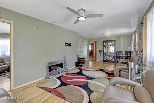 72 Mount Matterhorn Ln, Toms River, NJ 08753 - living area with a glass covered fireplace, visible vents, a healthy amount of sunlight, and wood finished floors