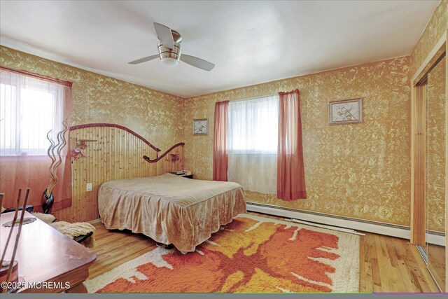 72 Mount Matterhorn Ln, Toms River, NJ 08753 - bedroom with a baseboard radiator, wood finished floors, a ceiling fan, and wallpapered walls