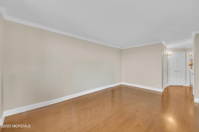 unfurnished room with wood finished floors, baseboards, and ornamental molding