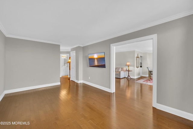 empty room with baseboards, wood-type flooring, and ornamental molding