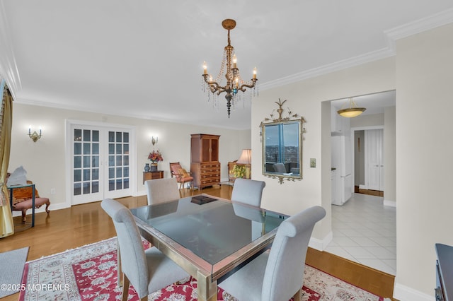 dining area with ornamental molding, wood finished floors, baseboards, and a chandelier