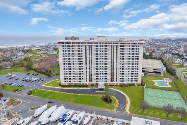 view of building exterior featuring a water view and uncovered parking