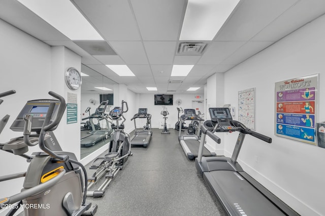 exercise room featuring baseboards, visible vents, and a drop ceiling