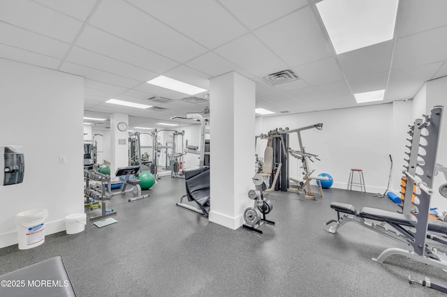 workout area with visible vents, baseboards, and a drop ceiling