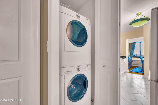 laundry room with laundry area, light tile patterned floors, and stacked washer / drying machine