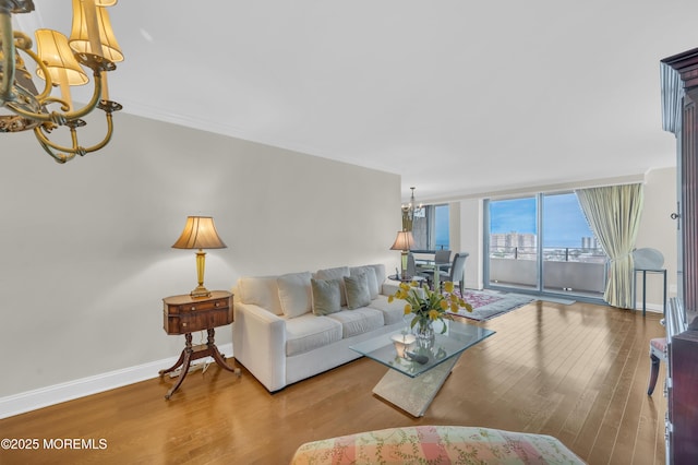 living room with baseboards, an inviting chandelier, and wood finished floors