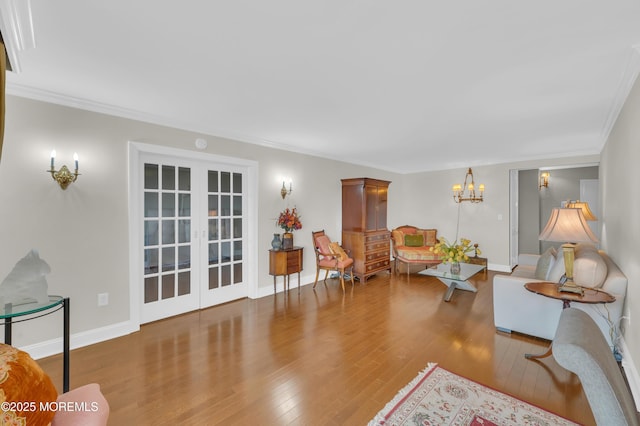 living room with crown molding, a notable chandelier, french doors, and wood-type flooring