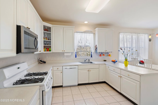 kitchen featuring a sink, white cabinetry, white appliances, a peninsula, and light countertops