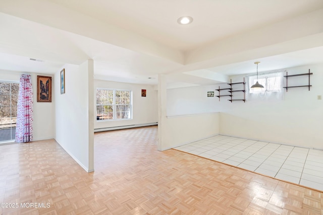 spare room featuring visible vents, baseboards, and baseboard heating