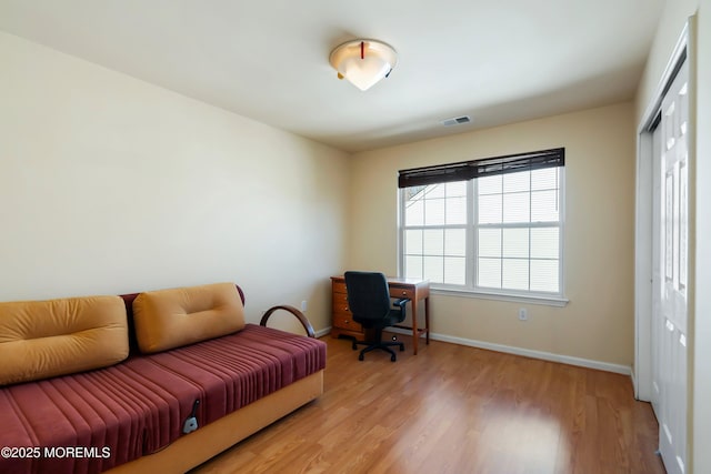 office space with baseboards, visible vents, and light wood-type flooring