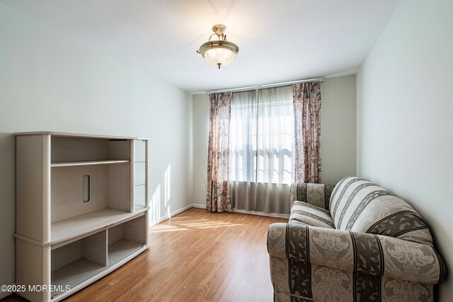 living area with baseboards and wood finished floors