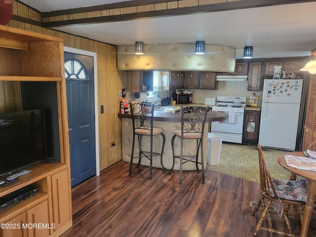kitchen with dark wood-style floors, white appliances, a peninsula, and under cabinet range hood