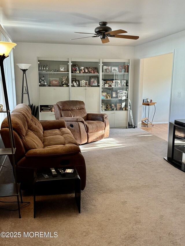 living area with a ceiling fan and carpet floors