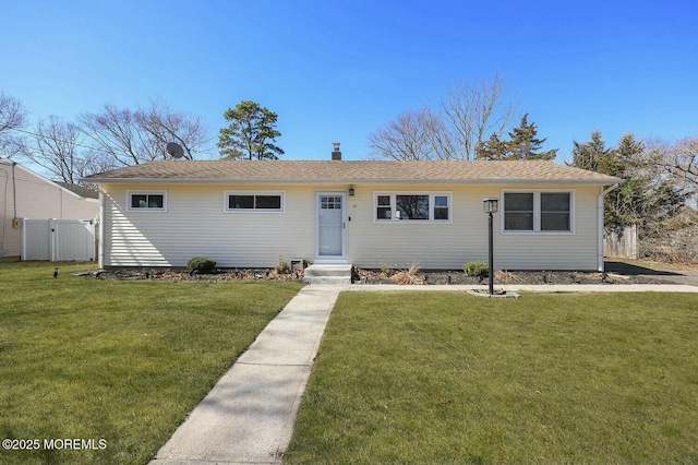 ranch-style house with a chimney, a front lawn, and fence