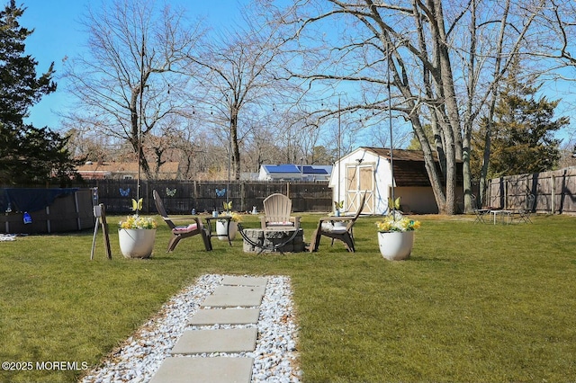 view of yard with an outbuilding, a storage unit, and a fenced backyard