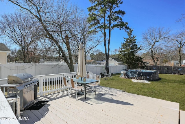 wooden deck featuring a yard, a fenced in pool, a grill, and a fenced backyard