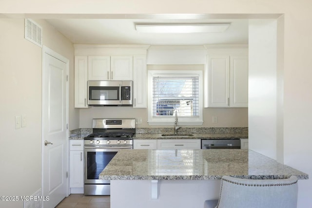 kitchen with white cabinets, appliances with stainless steel finishes, and a sink